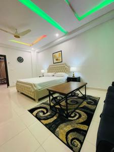Un dormitorio con una cama y una mesa sobre una alfombra en Elegant 2 Bed Apartment Tranquil Stays, en Islamabad