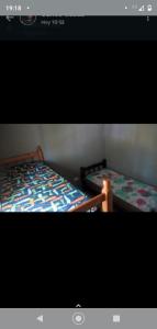 deux lits côte à côte dans une pièce dans l'établissement Cabañas La Mimi, à Villa Anizacate