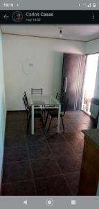 une salle à manger avec une table en verre et deux chaises dans l'établissement Cabañas La Mimi, à Villa Anizacate 2 autres photos