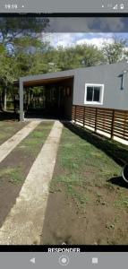 une maison avec un garage et une cour herbeuse dans l'établissement Cabañas La Mimi, à Villa Anizacate