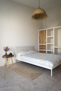 una camera da letto bianca con un letto e un tavolo di B&B Casa Areia a Colares