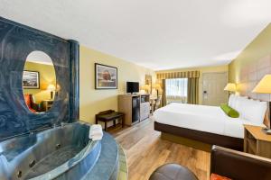 a hotel room with a bed and a bath tub at Best Western Dayton in Dayton +16 photos