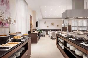 a restaurant with a buffet line with food on display at Ramada Hotel & Suites by Wyndham Yerevan in Yerevan