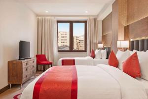 a hotel room with two beds and a television at Ramada Hotel & Suites by Wyndham Yerevan in Yerevan