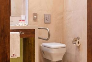 a bathroom with a white toilet and a sink at Ramada Hotel & Suites by Wyndham Yerevan in Yerevan
