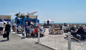 eine Menschenmenge sitzt am Strand in der Unterkunft Regal, West Sands, Seal Bay Resort, Selsey in Selsey