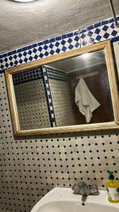 un bagno con specchio sopra un lavandino di Dar El Arfaoui a Fes