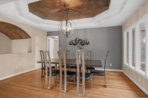 comedor con mesa, sillas y techo en Luxurious Private Lakefront Paradise home, en Mooresville