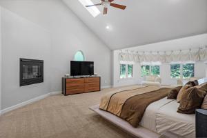 Un dormitorio con una cama grande y un televisor de pantalla plana. en Luxurious Private Lakefront Paradise home, en Mooresville