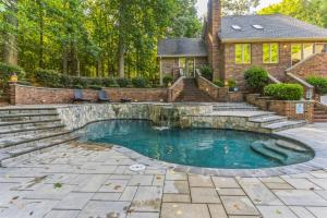 una piscina en el patio trasero de una casa con una casa en Luxurious Private Lakefront Paradise home, en Mooresville