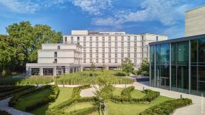 ein Bürogebäude mit einem Garten davor in der Unterkunft Dorint Parkhotel Frankfurt / Bad Vilbel in Bad Vilbel
