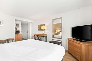 una camera d'albergo con un letto e una TV a schermo piatto di Sonesta Anaheim Resort Area ad Anaheim Altre 34 foto
