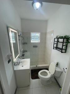 un bagno bianco con un water e un lavandino di Weekendz- Cozy 2BRD Suite a Port Antonio
