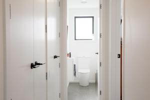 a bathroom with white walls and a toilet in it at Wanakas home away from home in Wanaka +16 photos