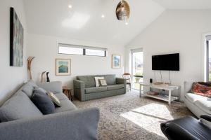 a living room with a couch and a tv at Wanakas home away from home in Wanaka