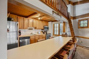 a kitchen with wooden cabinets and a long counter top at Hot Tub, Loft with Balcony, Great Views, 2 Bedrooms, 30 Plus Night Rentals Welcome in Steamboat Springs +34 photos