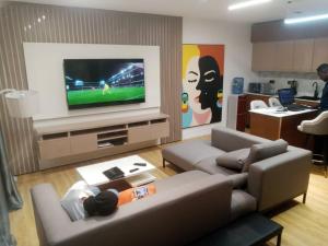 a living room with a couch and a flat screen tv at Nene Apartment in Abuja