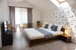 Un dormitorio con una cama y una mesa y sillas. en Villa Hanna's Garden - Mintia, en Mintia