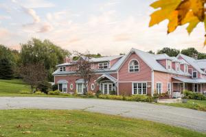 a large pink house with a driveway at Auberge Le Tricorne in North Hatley