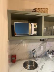 eine Küchentheke mit Spüle und Mikrowelle in der Unterkunft Jardim Paulista Apartamento com Vista in São Paulo