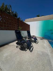 two chairs sitting on a patio next to a fence at advengers Bucerias Nayarti in Bucerías