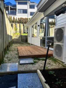 a backyard with a wooden deck next to a house at Self contained central Silverdale in Silverdale