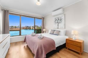 Un dormitorio con una cama y una ventana grande. en Stunning Lake View Townhouse-Dream Staycation, en Cheltenham