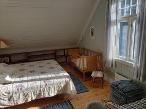a bedroom with a bed and a crib and a window at Landlig idyll 200 meter fra sjøen in Lillesand
