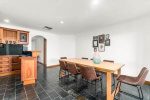 une salle à manger avec une table et des chaises dans l'établissement Coastal Comfort 4BR Vacation Home in Hallett Cove, à Halletts Cove 19 autres photos
