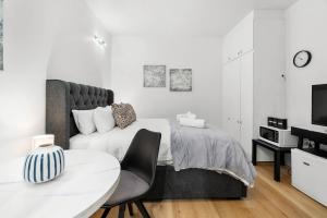 Un dormitorio con una cama, una mesa y un televisor. en Charming City Escape Stylish CBD Suite with WiFi, en Adelaida