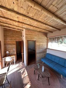 a living room with a blue couch and a table at ALDEA DEL MAR by Villa del Sol in Máncora