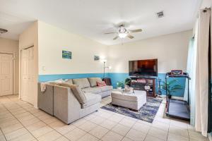 a living room with a couch and a tv at Peaceful Biloxi Getaway - 7 Mi to Beach and Downtown in Biloxi