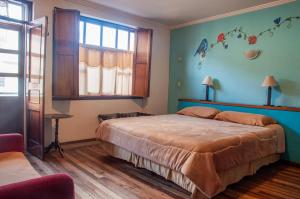 a bedroom with a large bed and a window at Hotel Casa de las Rosas in Cuenca