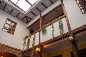 a building with a balcony with plants on it at Hotel Casa de las Rosas in Cuenca