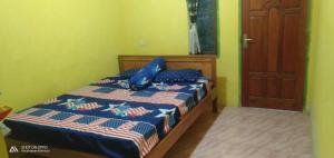 克里穆图Febryan Guest house的一间卧室，床上有一个蓝色枕头