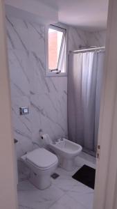 a white bathroom with a toilet and a shower at Torre Paraná in Paraná +3 photos