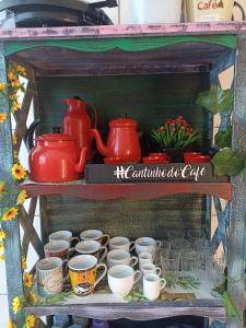 a shelf with cups and pitchers on it at Casa para 12 pessoas perto da Basílica e da Feira in Aparecida +10 photos