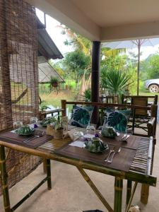 a wooden table with plates of food on it at Baan Hug Na in Ban Khao Chakan