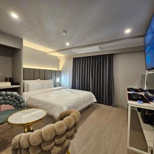 a hotel room with a bed and a tv at Denbasta Hotel Choeup in Busan