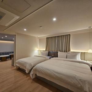 a hotel room with two beds and a couch at Denbasta Hotel Choeup in Busan +20 photos