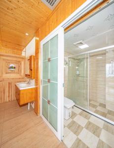 a bathroom with a shower and a toilet and a sink at Longji Panorama Hotel 龙脊全景楼大酒店 in Longsheng