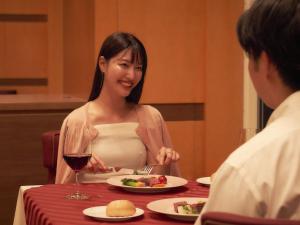 a woman sitting at a table with a plate of food at Hakodate-Onuma Prince Hotel in Nanae +118 photos