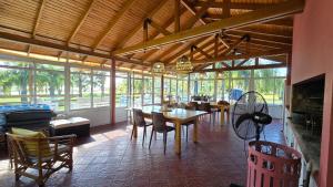 Un comedor con mesas y sillas y ventanas. en Paso De La Barca, en Federación