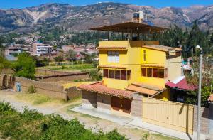 a yellow building with a tower on top of it at Casa Alojamiento Tocllaraju in Tarica