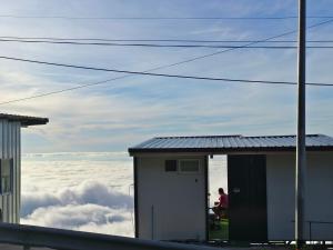 a person sitting in a chair in a building above the clouds at ชาร์จแบต ภูทับเบิก in Ban Muang Baeng