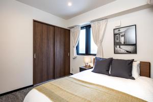 a bedroom with a large bed and windows at AI Annex in Osaka