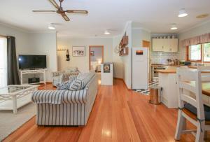 Una sala de estar con dos sofás y una cocina. en Bright Country Home, en Bright