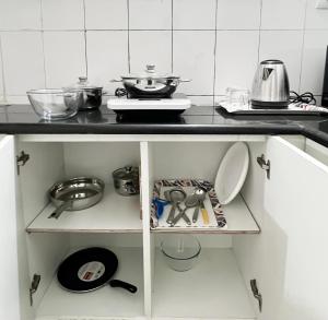 a kitchen with a counter with dishes and pans at The Pinnacle - Electronic City in Bengaluru