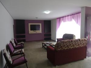 a living room with a couch and a tv at Iria's Hotel in Timbó
