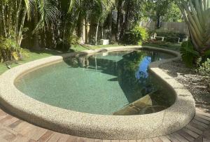 a swimming pool with a circular coping in a yard at Belle Escapes Sandpipers Beach House in Palm Cove